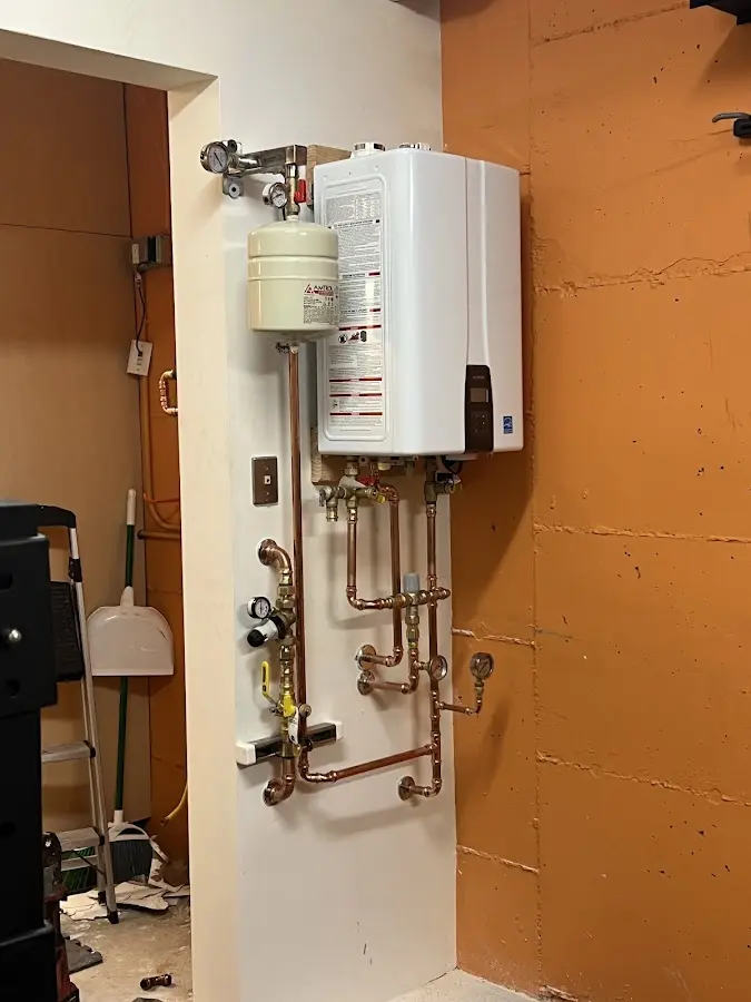 Plumbing technician inspecting water heater connections in Delshire